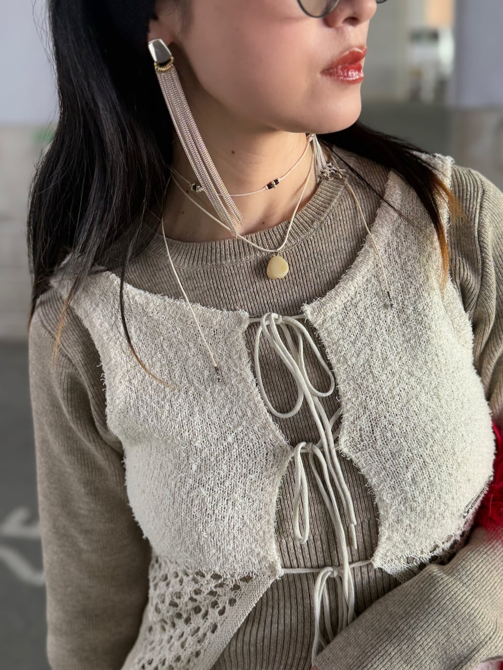 ホワイト系のニット/セーター、ホワイト系のタンクトップ、レッド系のトートバッグを着用したレディースの冬コーディネートの4枚目の写真