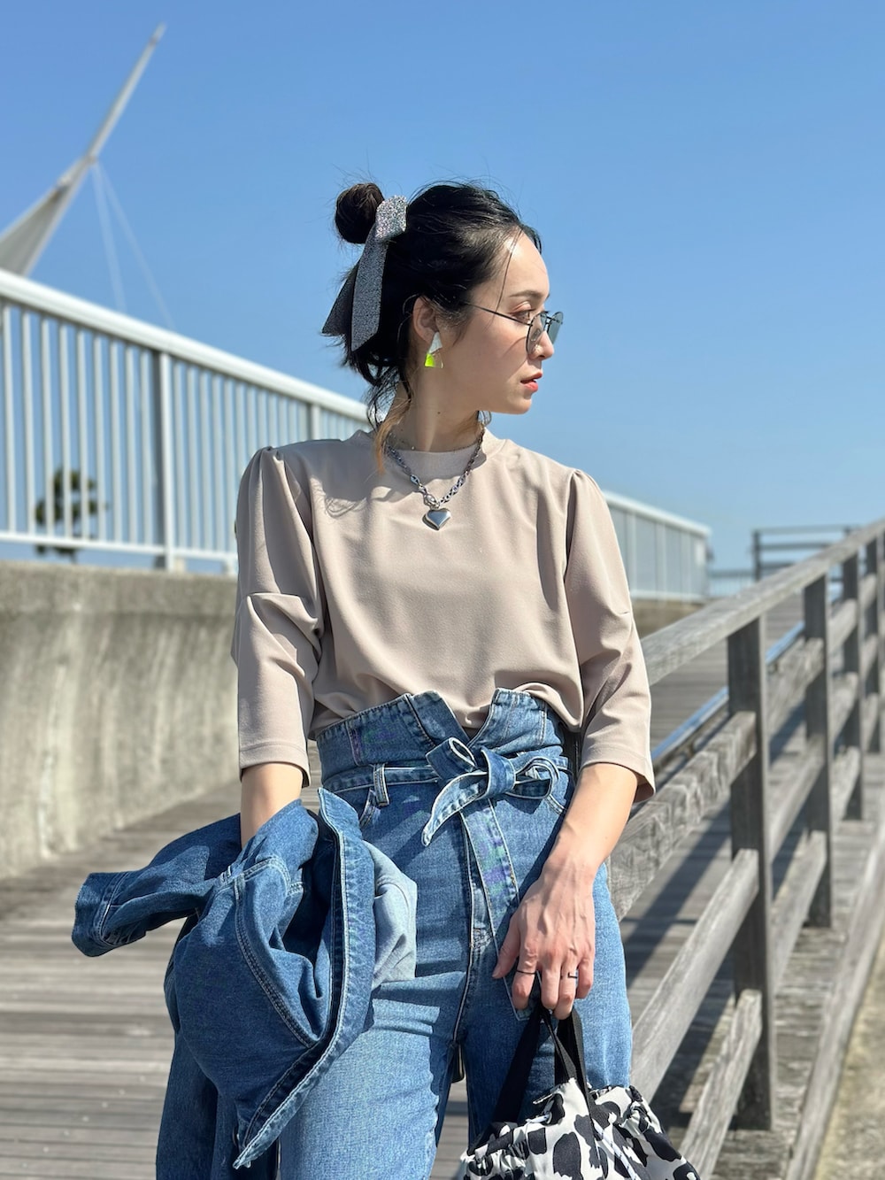 ベージュ系のTシャツ/カットソー、ブルー系のデニムジャケット、ベージュ系のスニーカーを着用したレディースの春コーディネートの2枚目の写真