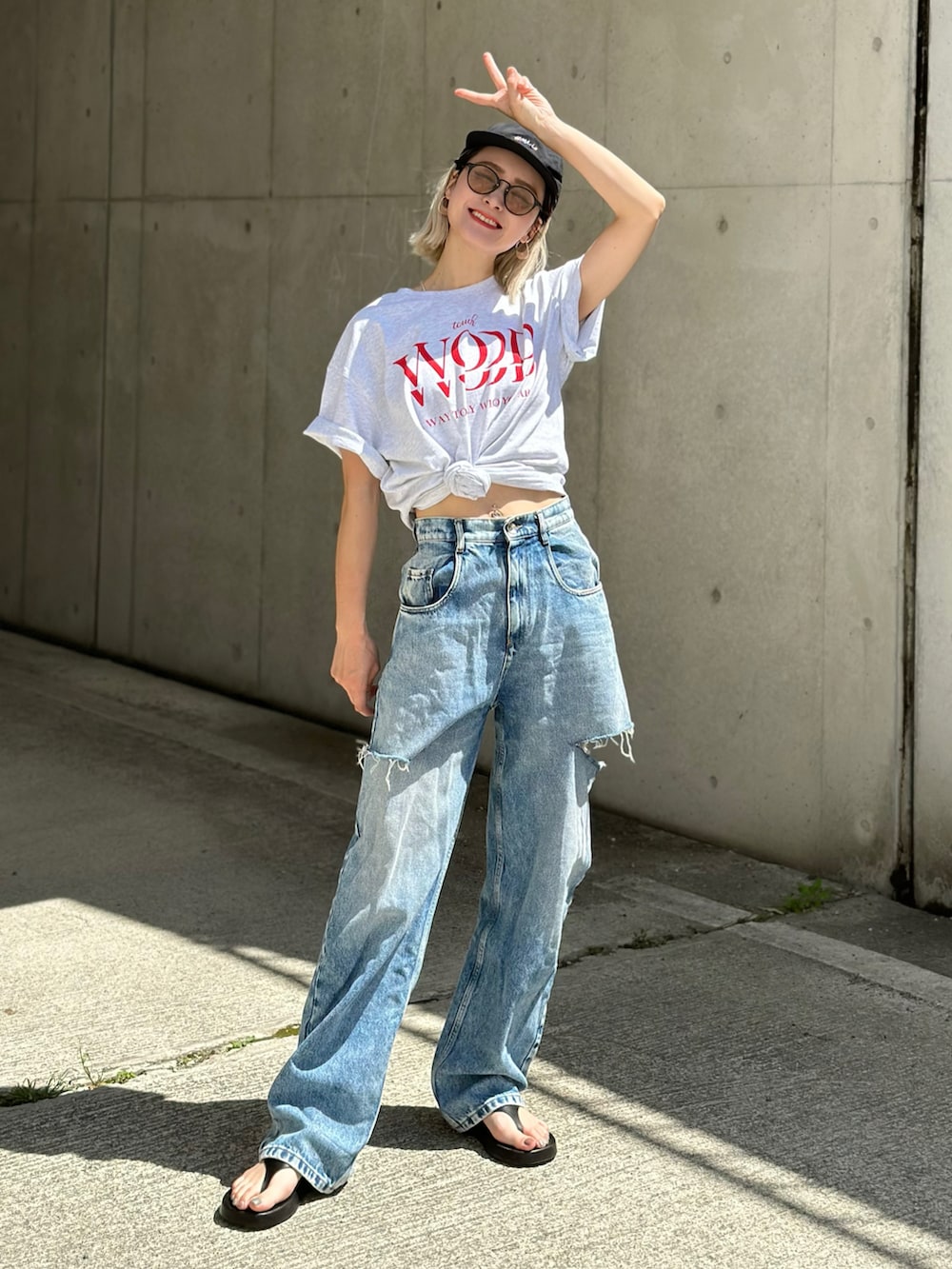 ベージュ系のTシャツ/カットソー、ホワイト系のチノパンツ、ブラック系のトートバッグを着用したレディースの春コーディネートの2枚目の写真