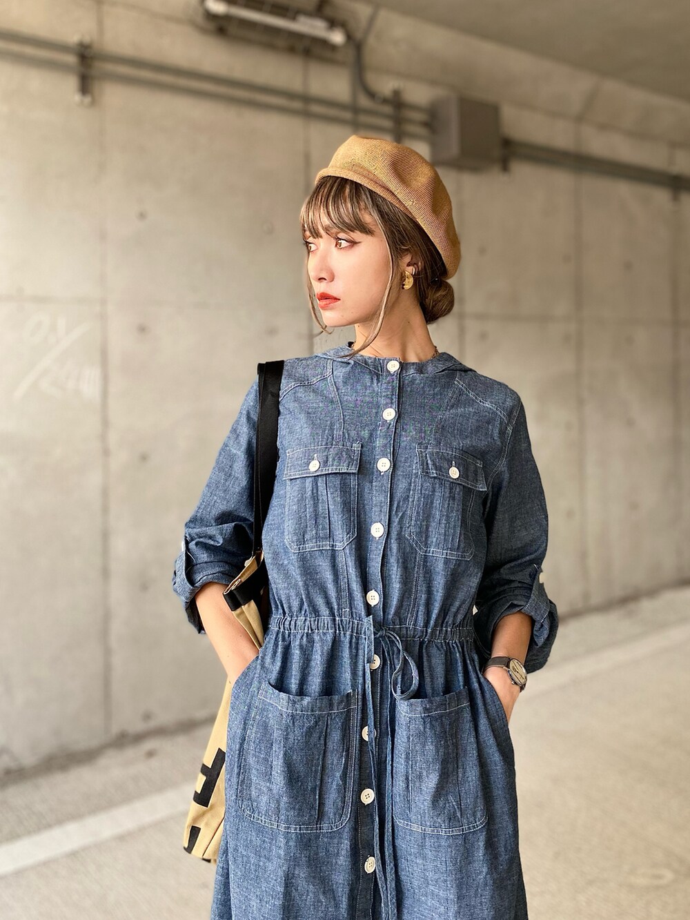 ブルー系のシャツワンピース、ベージュ系のトートバッグ、ブラウン系のサンダルを着用したレディースの春コーディネートの2枚目の写真