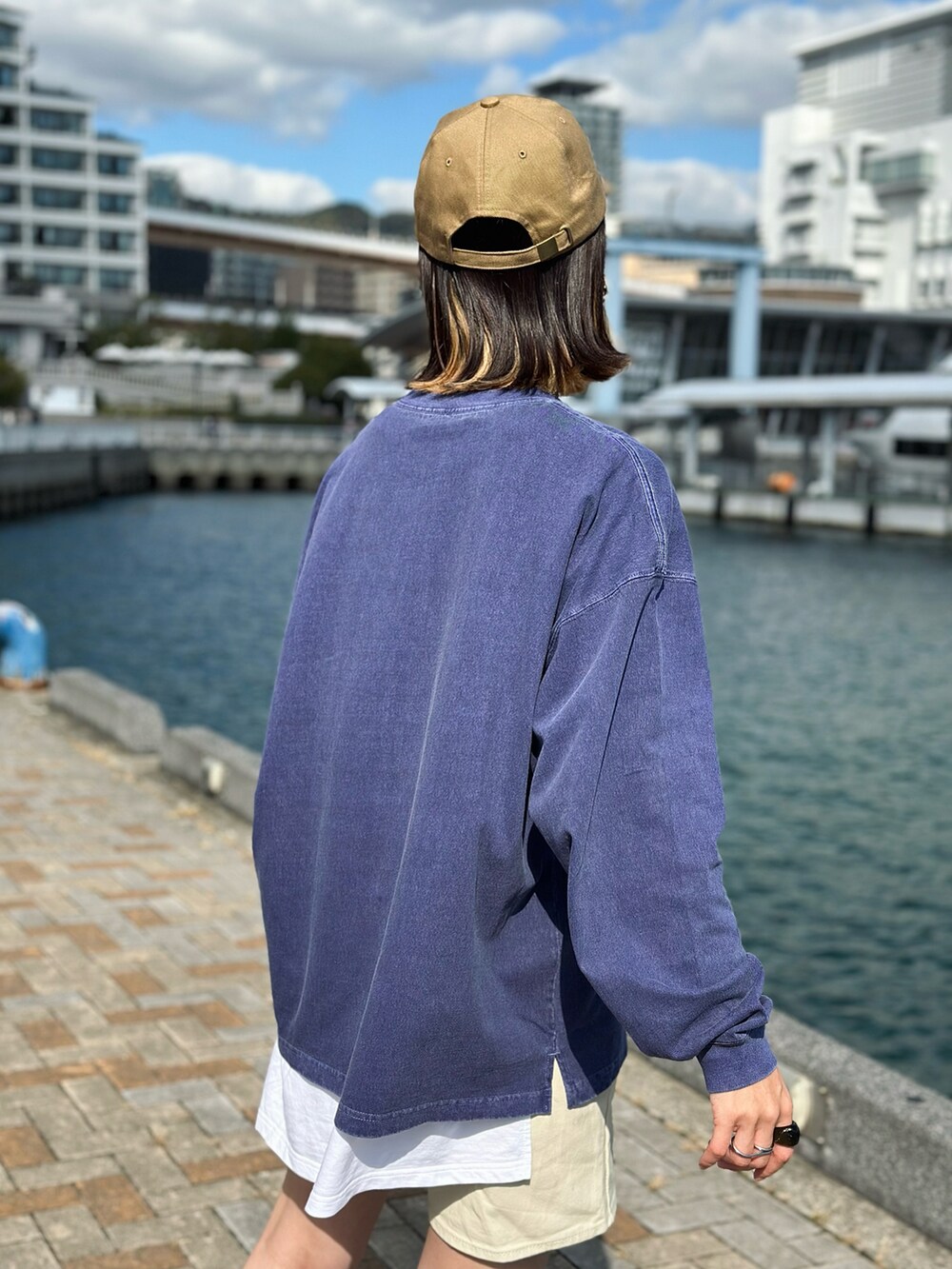 ブルー系のTシャツ/カットソー、イエロー系のベスト、ホワイト系のその他パンツを着用したレディースの冬コーディネートの4枚目の写真