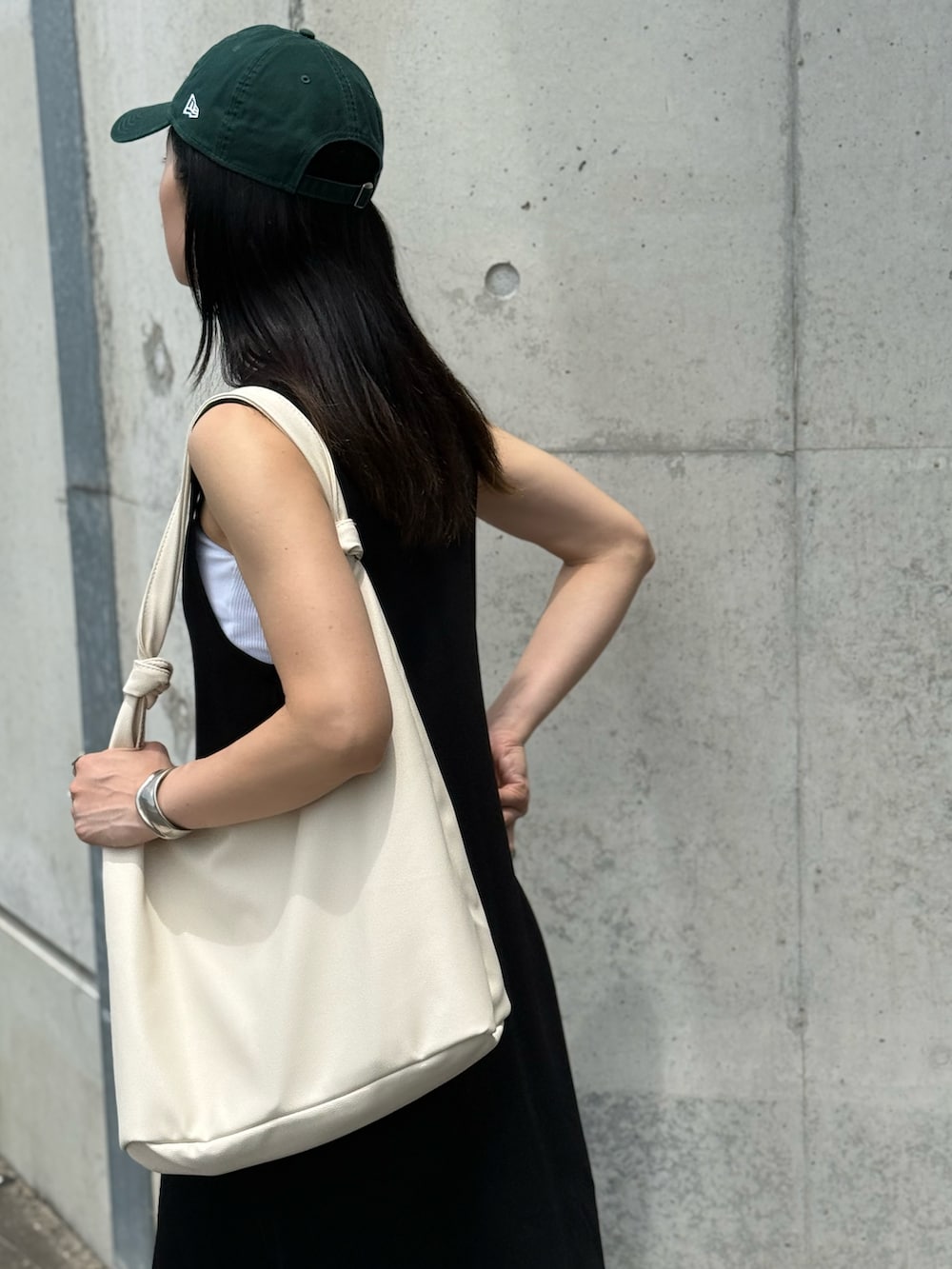 ホワイト系のキャミソール、ホワイト系のトートバッグ、ブラック系のワンピースを着用したレディースの夏コーディネートの3枚目の写真