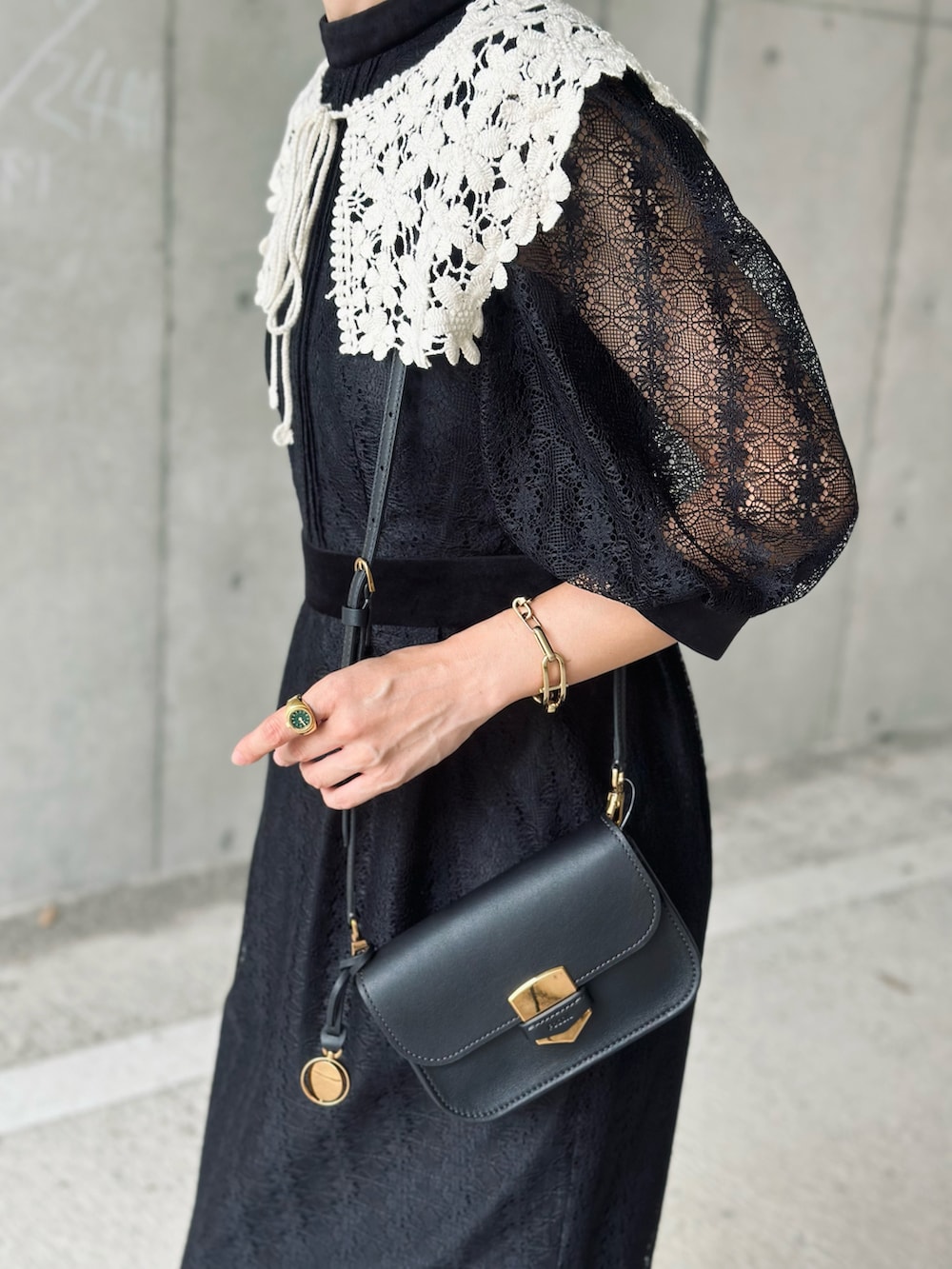 ブラック系のワンピース、ブラック系のローファー、ブラック系のメッセンジャーバッグを着用したレディースの秋コーディネートの4枚目の写真