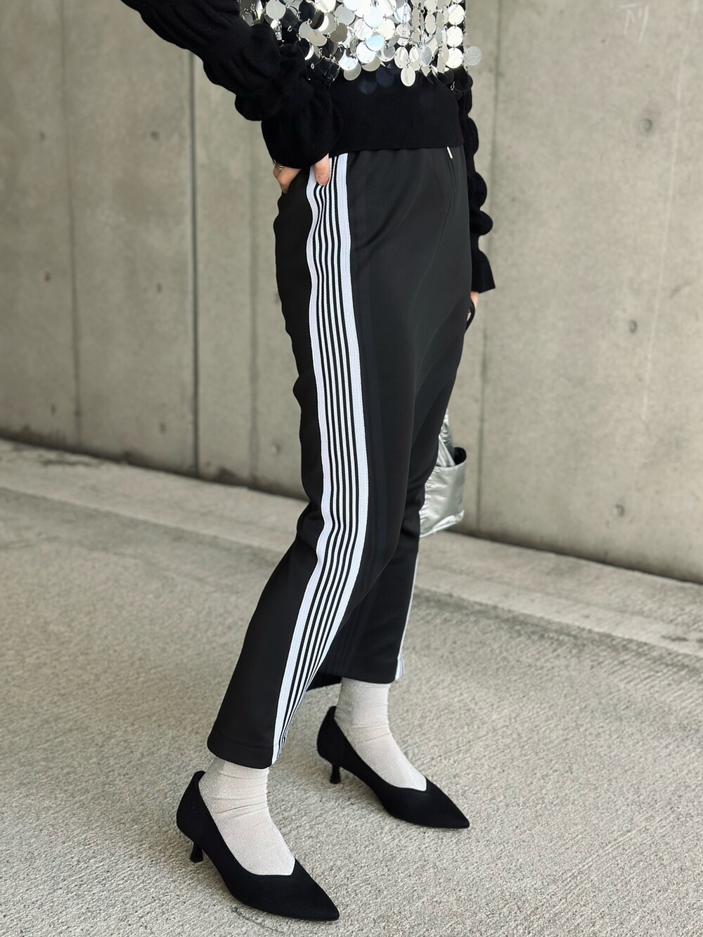 ブラック系のパンプス、シルバー系のハンドバッグ、ブラック系のスカートを着用したレディースの春コーディネートの4枚目の写真