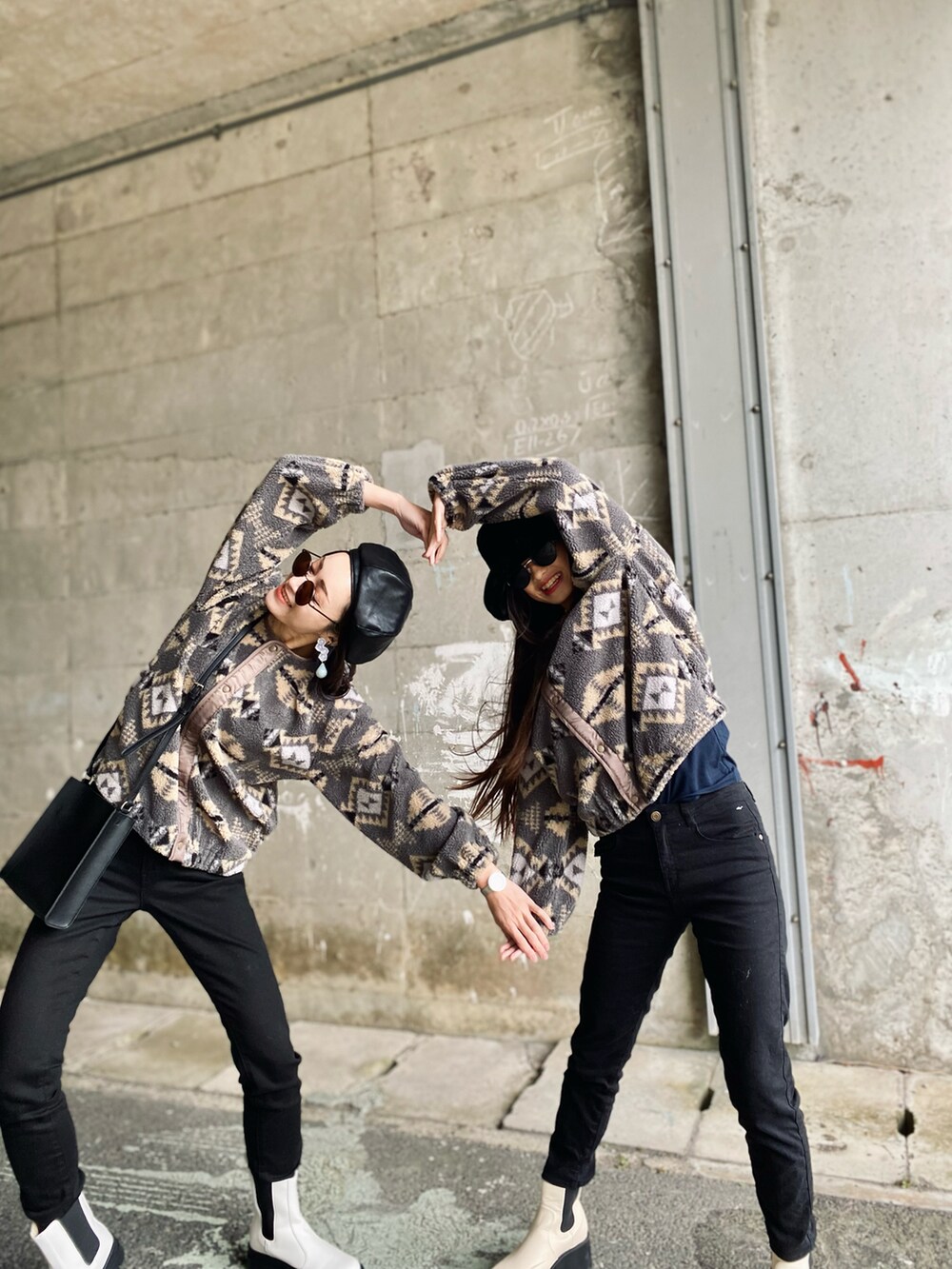 ブラック系のデニムパンツ、ブラック系のショルダーバッグ、ホワイト系のブーツを着用したレディースの秋コーディネートの5枚目の写真