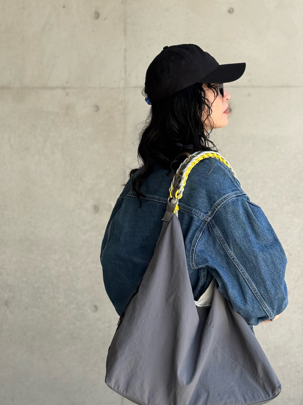 ホワイト系のTシャツ/カットソー、グレー系のショルダーバッグ、ブラック系のキャップを着用したレディースの春コーディネートの4枚目の写真