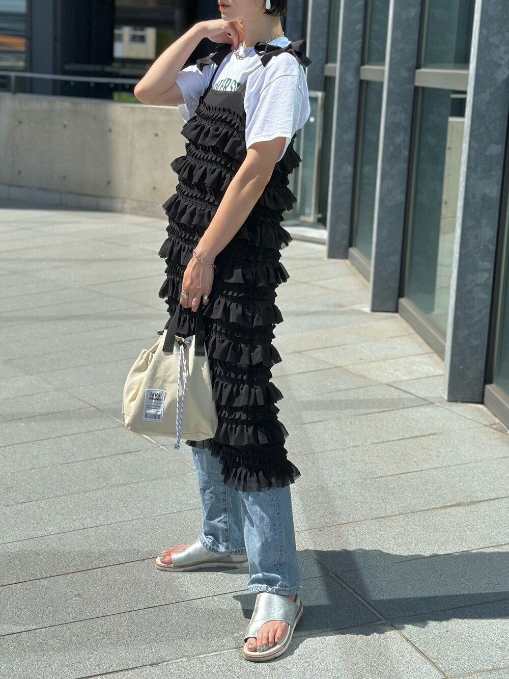 ブラック系のワンピース、ホワイト系のTシャツ/カットソー、ブルー系のデニムパンツを着用したレディースの春コーディネートの5枚目の写真