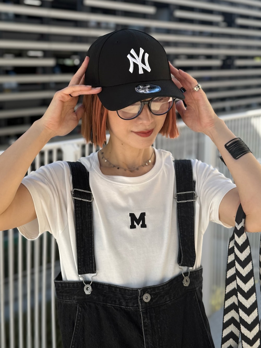 ホワイト系のTシャツ/カットソー、ホワイト系のスニーカー、ブラック系のバッグを着用したレディースの夏コーディネートの2枚目の写真