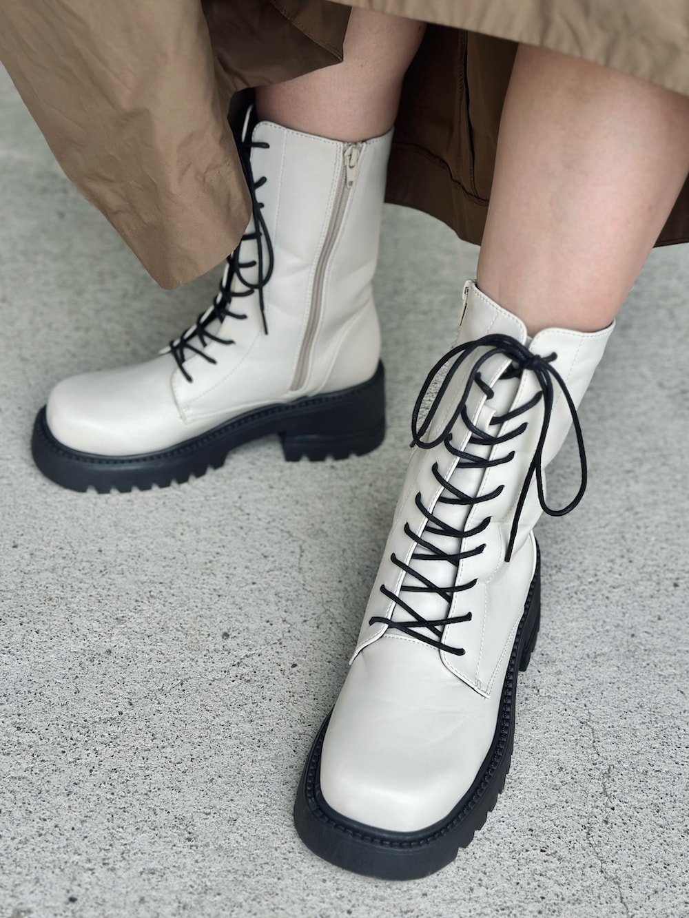 ベージュ系のワンピース、ホワイト系のブーツ、ホワイト系のTシャツ/カットソーを着用したレディースの秋コーディネートの3枚目の写真