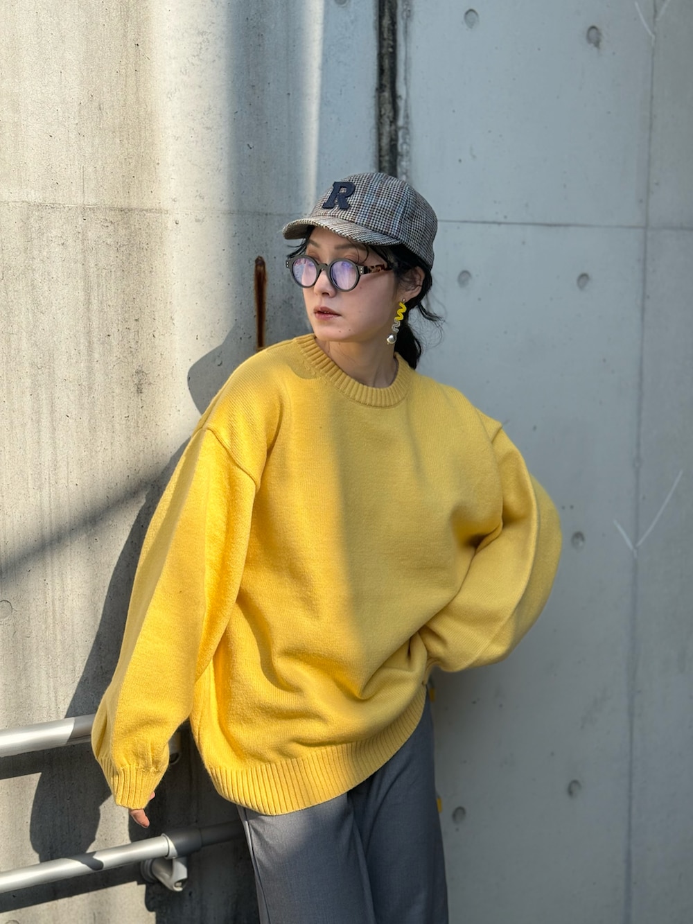 イエロー系のニット/セーター、グレー系のその他アウター、グレー系のスラックスを着用したレディースの春コーディネートの3枚目の写真