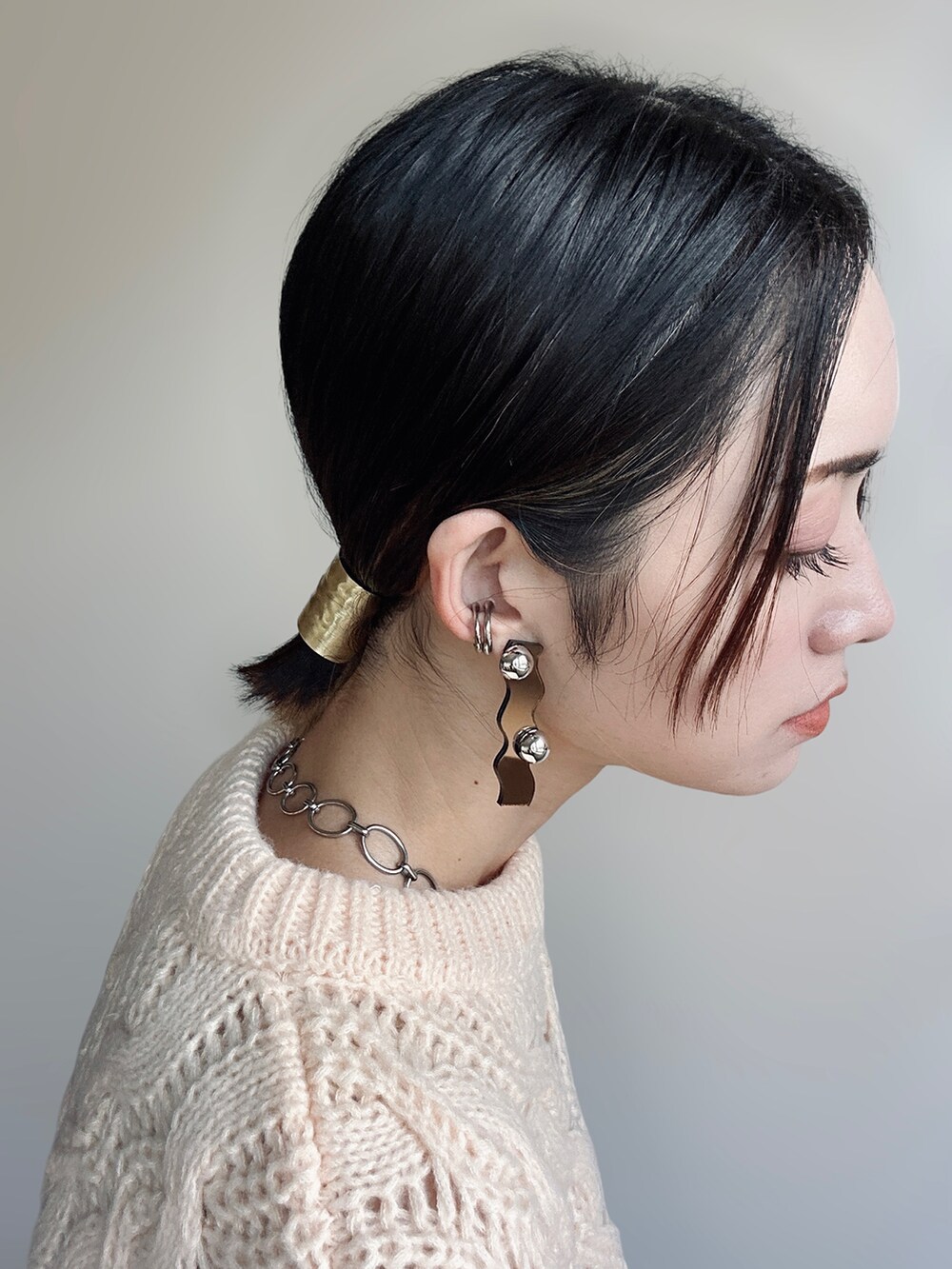 ホワイト系のトートバッグ、ホワイト系のパンプス、ブラック系のスラックスを着用したレディースの秋コーディネートの3枚目の写真