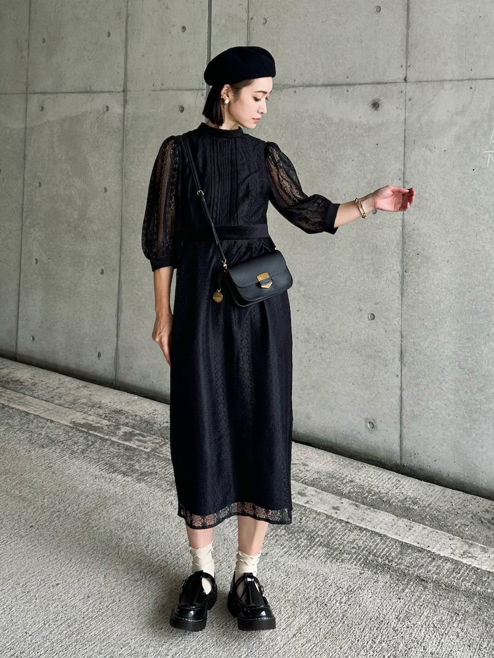 ブラック系のワンピース、ブラック系のローファー、ブラック系のメッセンジャーバッグを着用したレディースの秋コーディネートの5枚目の写真