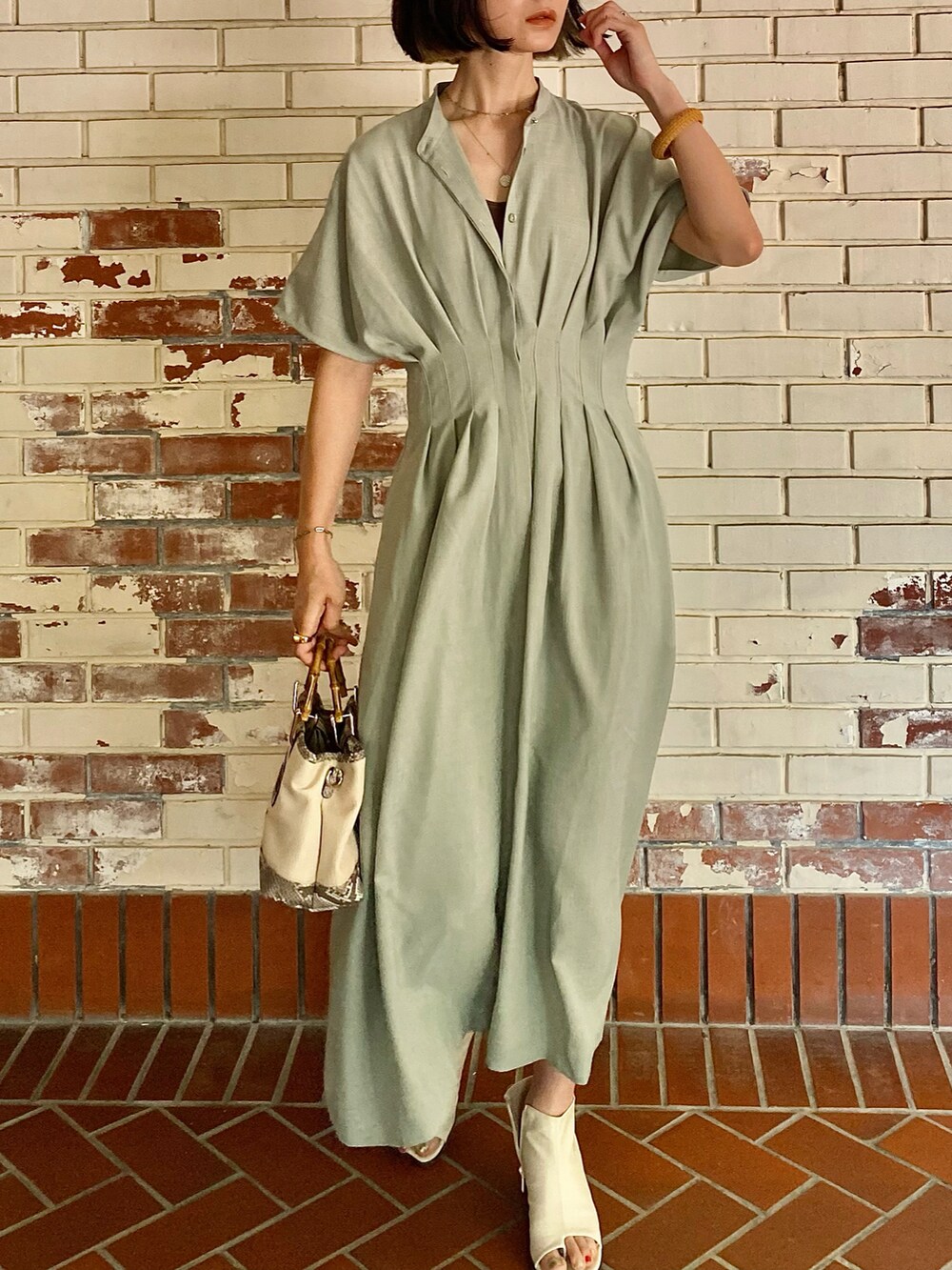 グリーン系のワンピース、その他のトートバッグ、ゴールド系のリングを着用したレディースの春コーディネートの5枚目の写真