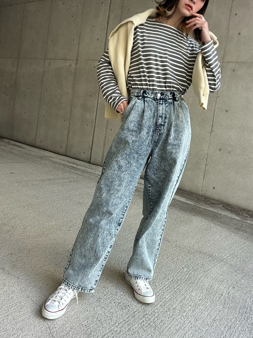 ホワイト系のトートバッグ、ブルー系のデニムパンツを着用したレディースの冬コーディネートの2枚目の写真