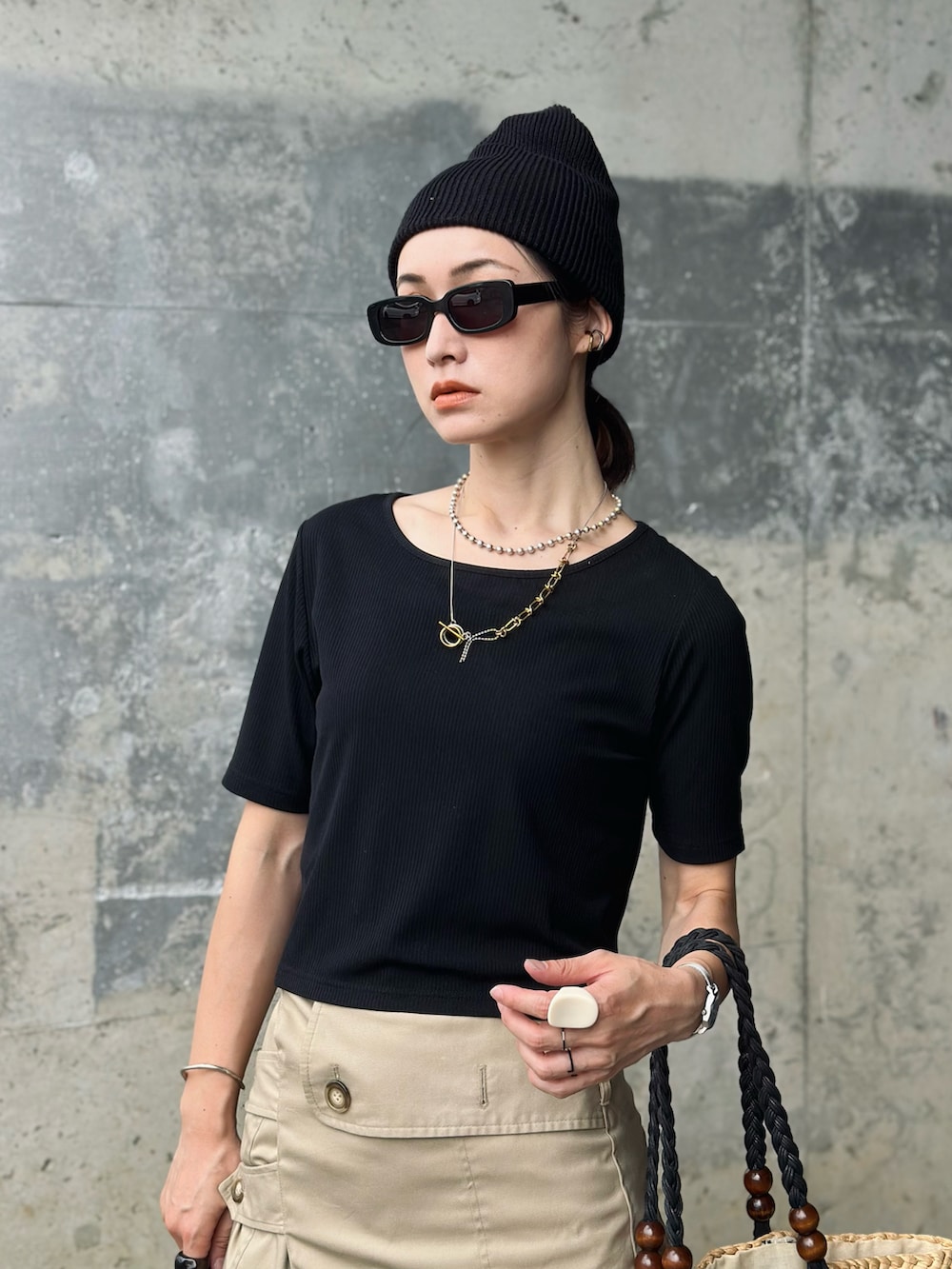 ブラック系のTシャツ/カットソー、ブラック系のパンプス、ゴールド系のネックレスを着用したレディースの夏コーディネートの2枚目の写真