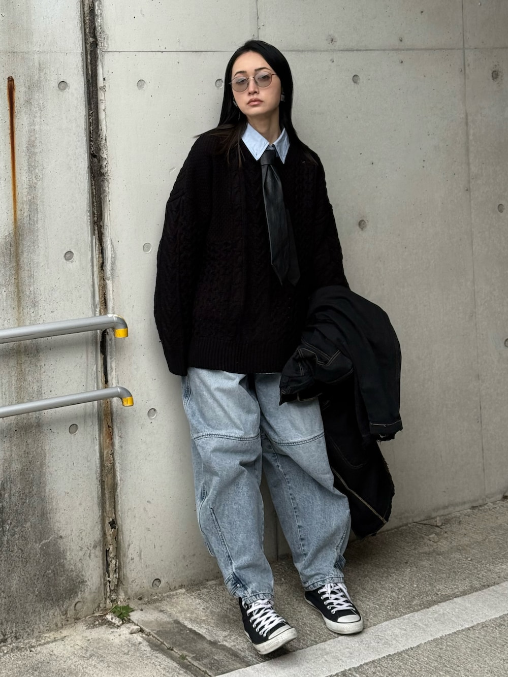 ブラック系のニット/セーター、ブルー系のデニムパンツ、その他のネクタイを着用したレディースの冬コーディネートの3枚目の写真