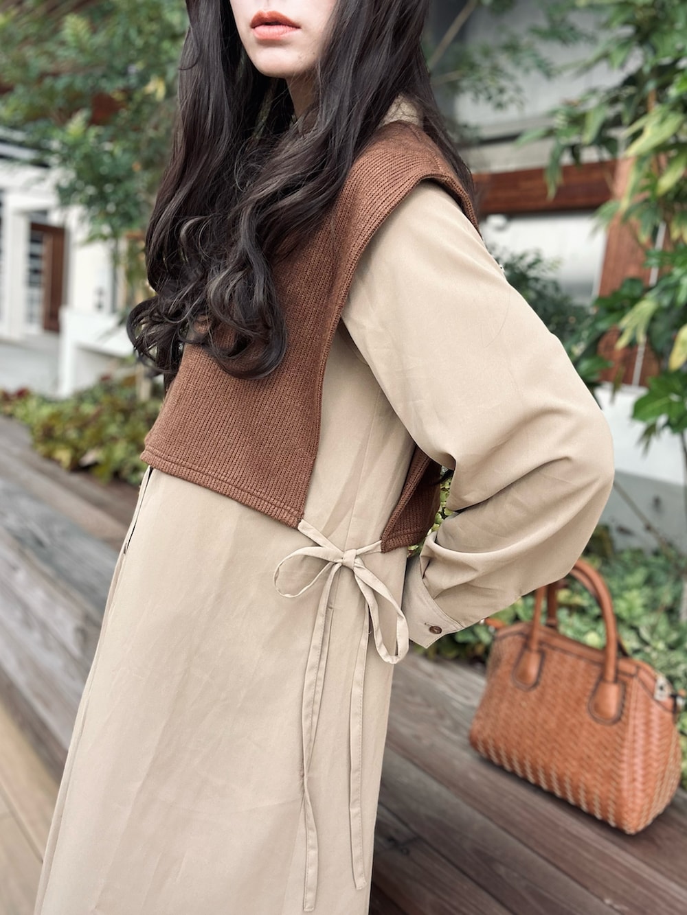 ブラウン系のブーツ、ベージュ系のワンピース、イエロー系のハンドバッグを着用したレディースの秋コーディネートの3枚目の写真