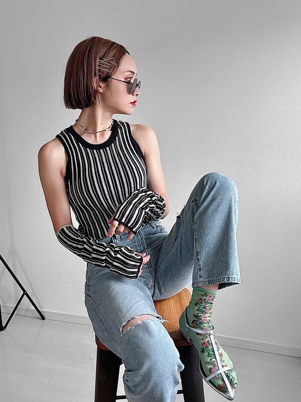 シルバー系のサンダル、ブラック系のニット/セーター、ブルー系のデニムパンツを着用したレディースの春コーディネートの5枚目の写真