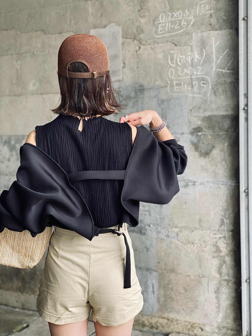 ブラック系のカーディガン/ボレロ、ベージュ系のチノパンツ、ブラウン系のサンダルを着用したレディースの春コーディネートの2枚目の写真