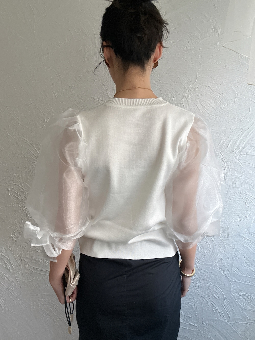 ホワイト系のTシャツ/カットソー、ブラック系のベスト、ブラック系のスカートを着用したレディースの冬コーディネートの4枚目の写真