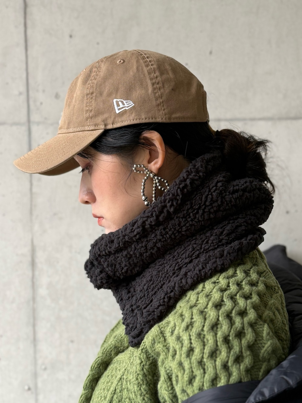 ブラック系のダウンジャケット/コート、ブラウン系のサロペット/オーバーオール、グリーン系のニット/セーターを着用したレディースの冬コーディネートの4枚目の写真