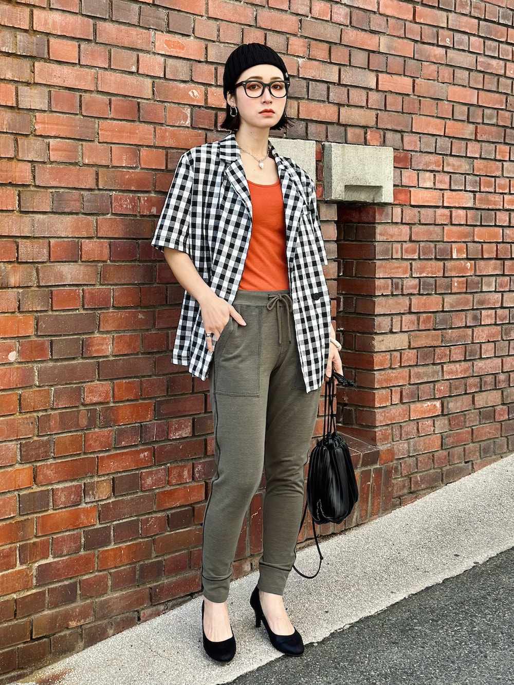 グリーン系のその他パンツ、オレンジ系のタンクトップ、ブラック系のパンプスを着用したレディースの春コーディネートの3枚目の写真