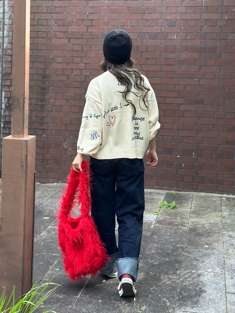 ホワイト系のニット/セーター、ブルー系のデニムパンツ、レッド系のトートバッグを着用したレディースの秋コーディネートの4枚目の写真