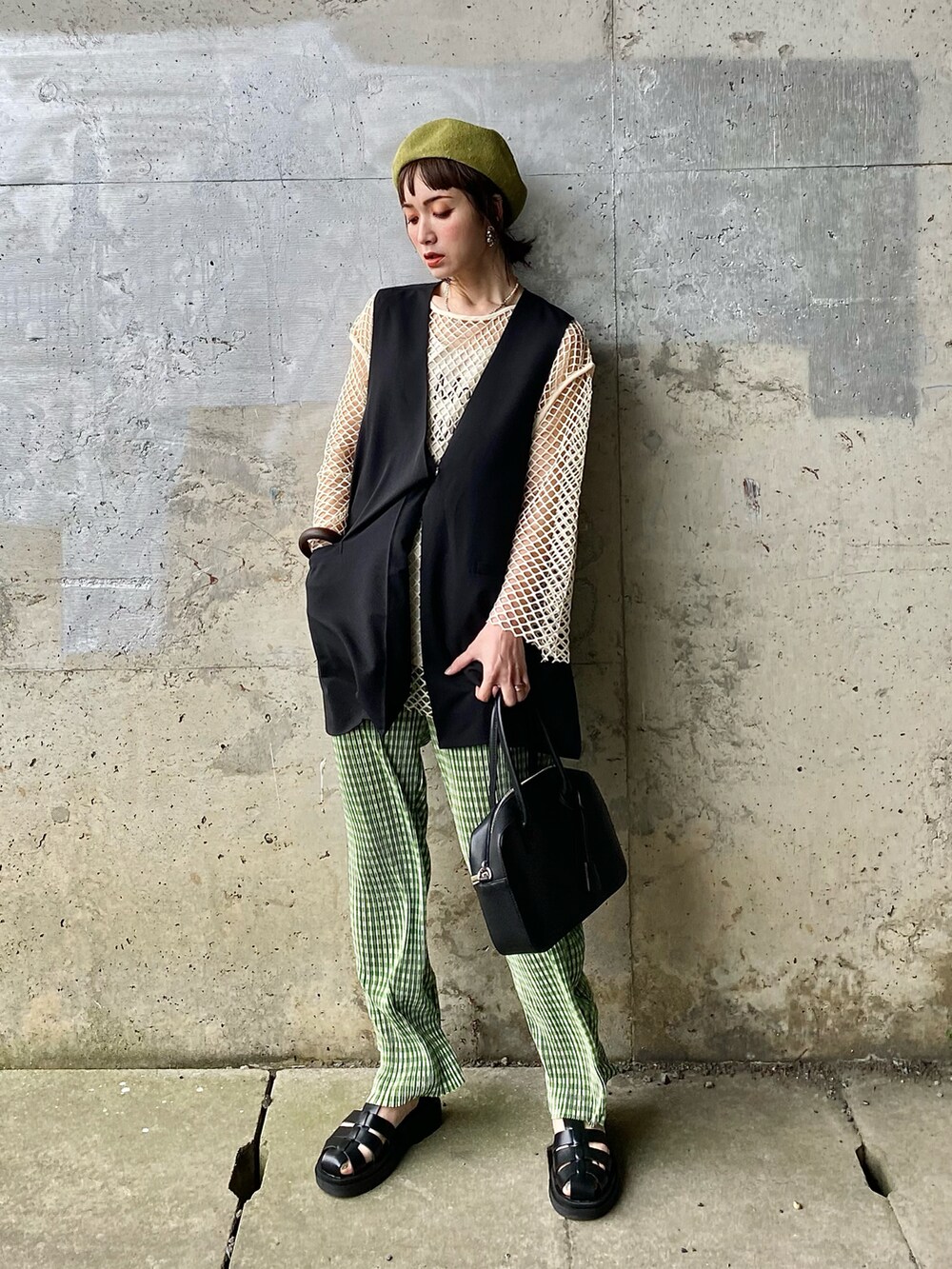ブラック系のベスト、グリーン系のその他パンツ、ブラック系のサンダルを着用したレディースの春コーディネートの5枚目の写真