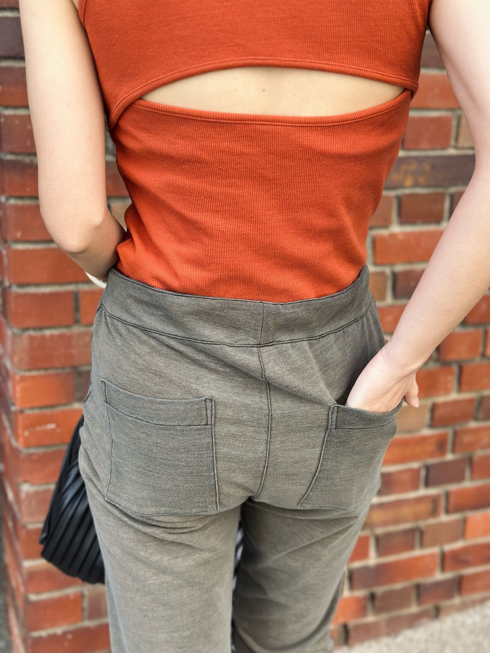 グリーン系のその他パンツ、オレンジ系のタンクトップ、ブラック系のパンプスを着用したレディースの春コーディネートの4枚目の写真