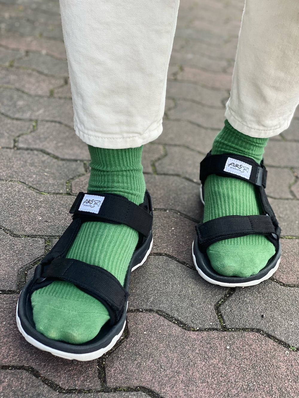 グリーン系のスウェット、ホワイト系のデニムパンツ、ブラック系のサンダルを着用したレディースの春コーディネートの4枚目の写真