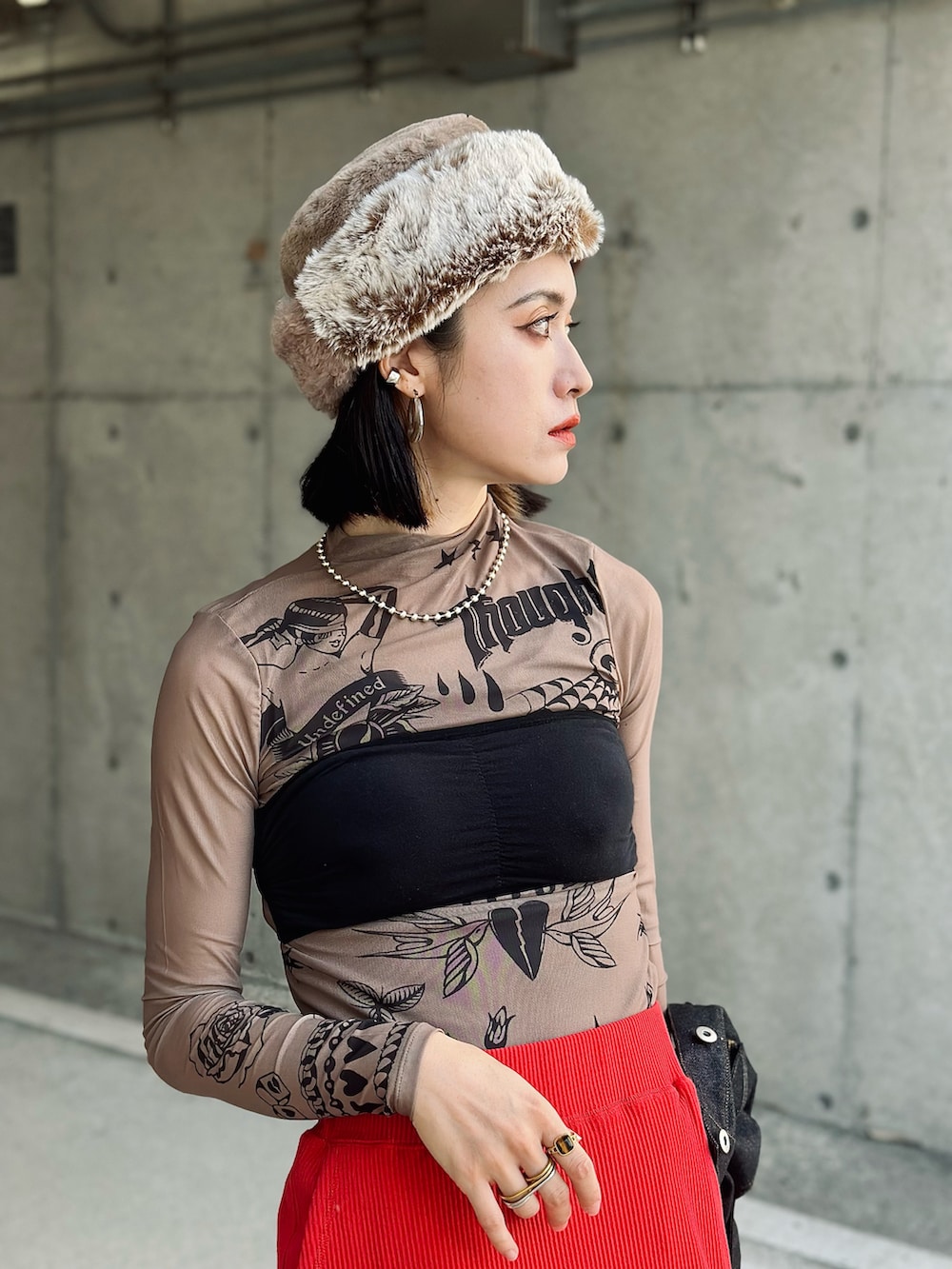 ブラック系のデニムジャケット、レッド系のスカート、ブラック系のハンドバッグを着用したレディースの秋コーディネートの4枚目の写真