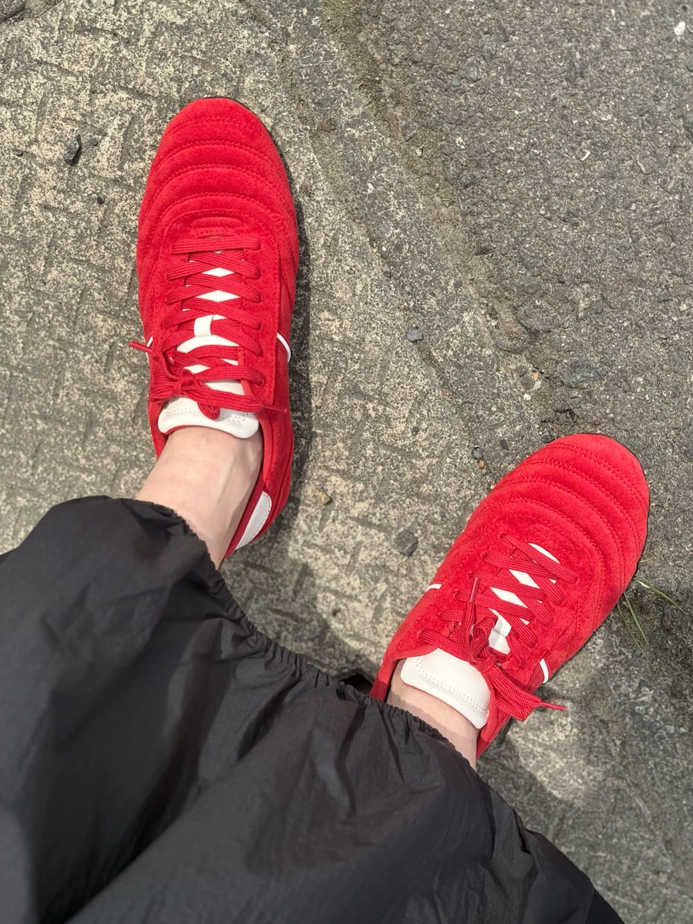 ブラック系のワンピース、レッド系のキャミソール、レッド系のスニーカーを着用したレディースの春コーディネートの3枚目の写真