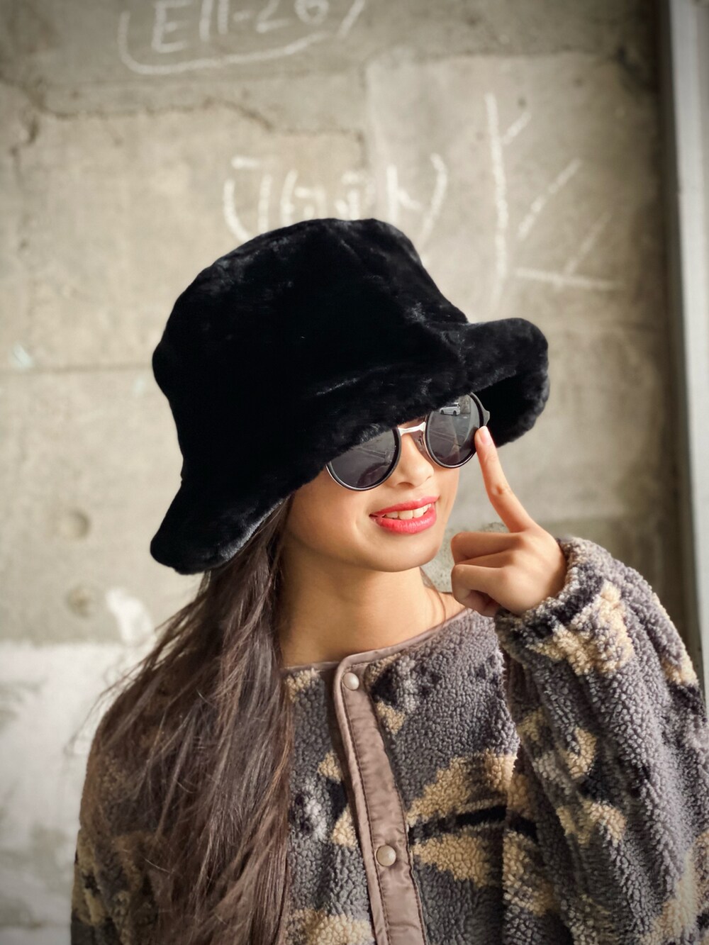 ブラック系のデニムパンツ、ブラック系のショルダーバッグ、ホワイト系のブーツを着用したレディースの秋コーディネートの4枚目の写真