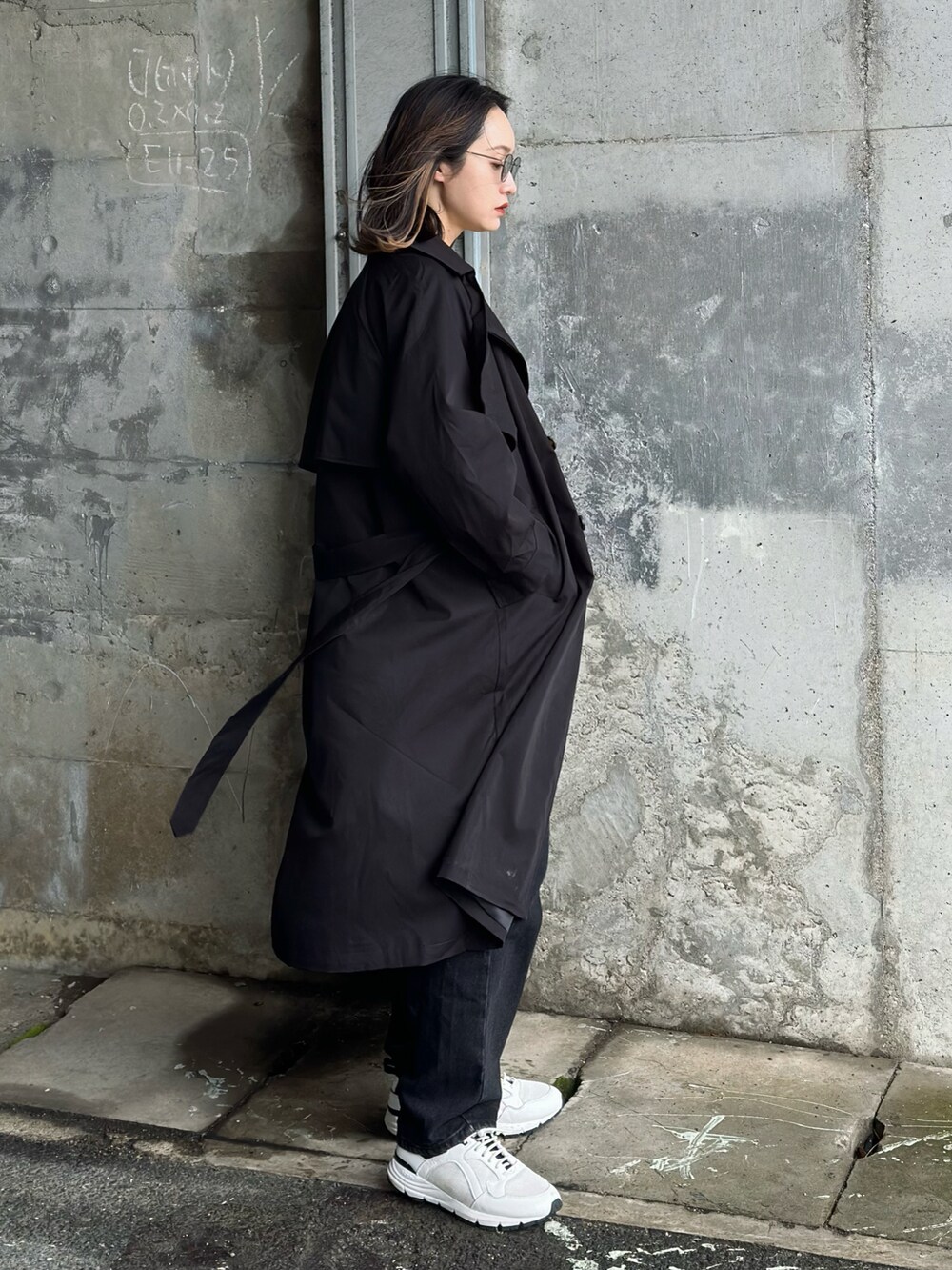 グリーン系のTシャツ/カットソー、ブラック系のトレンチコート、ブラック系のトートバッグを着用したレディースの春コーディネートの4枚目の写真