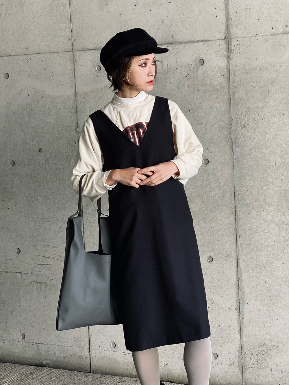 ホワイト系のブルゾン、ブラック系のワンピース、グレー系のショルダーバッグを着用したレディースの冬コーディネートの4枚目の写真