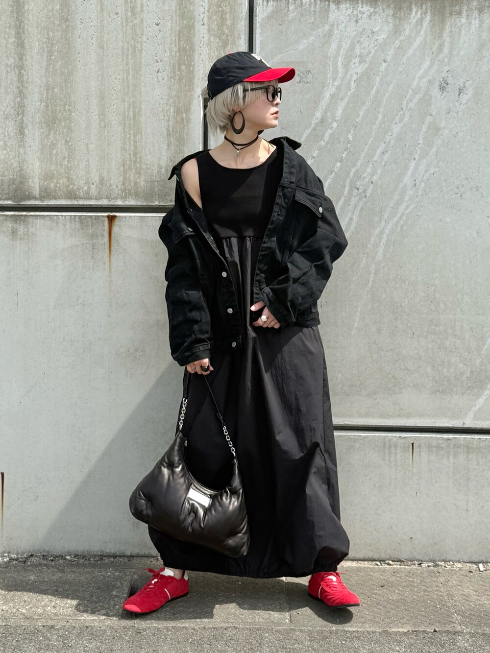 ブラック系のワンピース、レッド系のキャミソール、レッド系のスニーカーを着用したレディースの春コーディネートの4枚目の写真