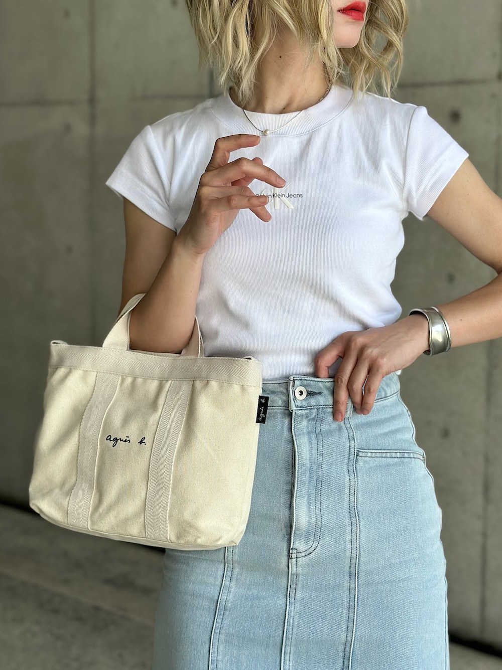 ブルー系のベスト、ブルー系のデニムスカート、ホワイト系のTシャツ/カットソーを着用したレディースの春コーディネートの4枚目の写真