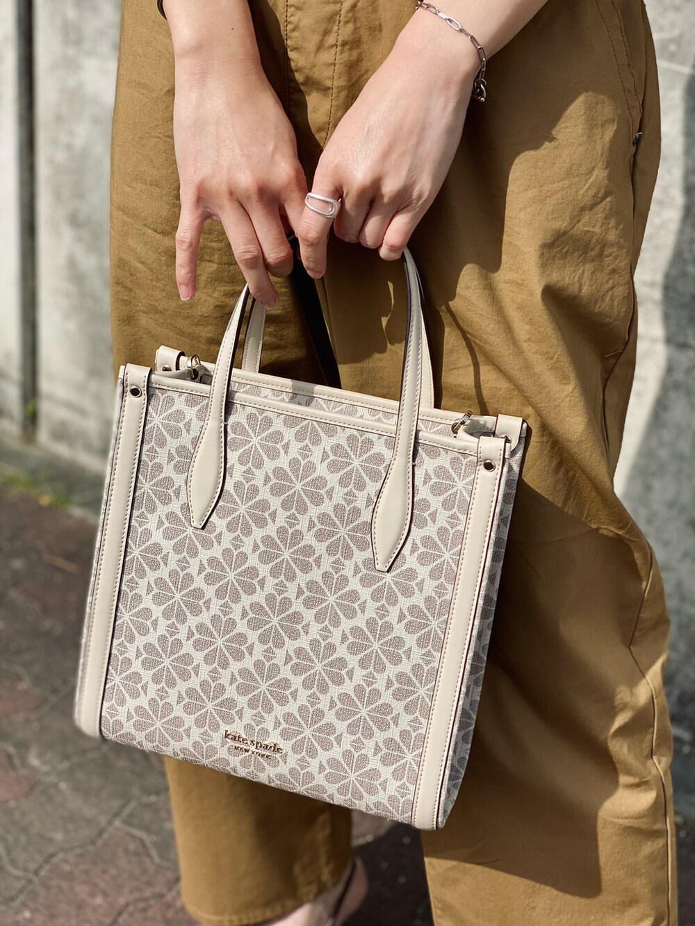 ブラック系のTシャツ/カットソー、ベージュ系のその他パンツ、ベージュ系のトレンチコートを着用したレディースの春コーディネートの3枚目の写真