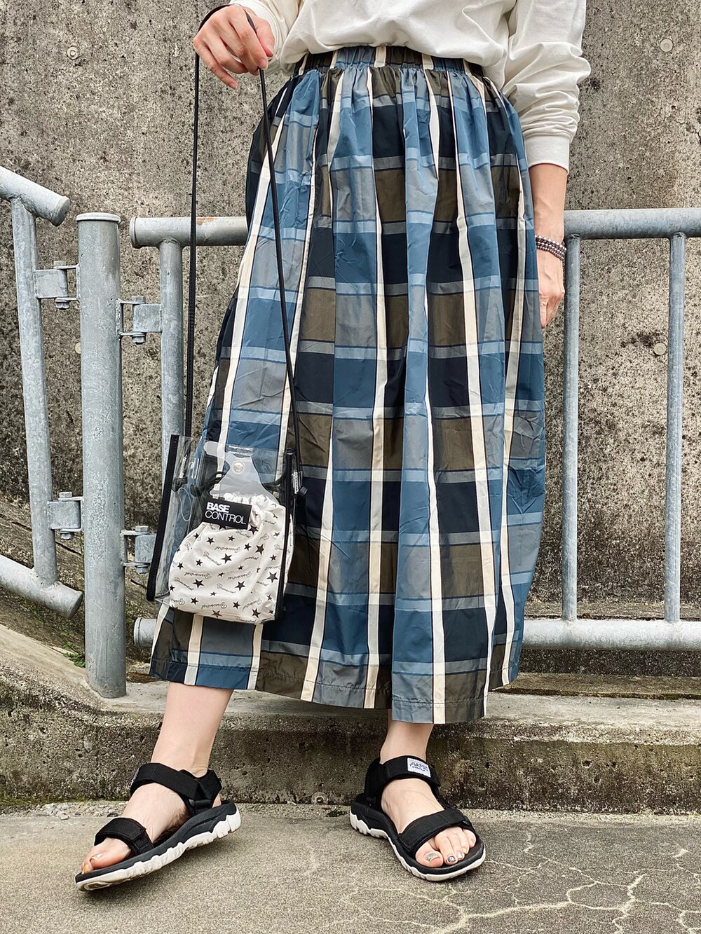 ベージュ系のTシャツ/カットソー、ホワイト系のショルダーバッグ、ブルー系のスカートを着用したレディースの春コーディネートの2枚目の写真