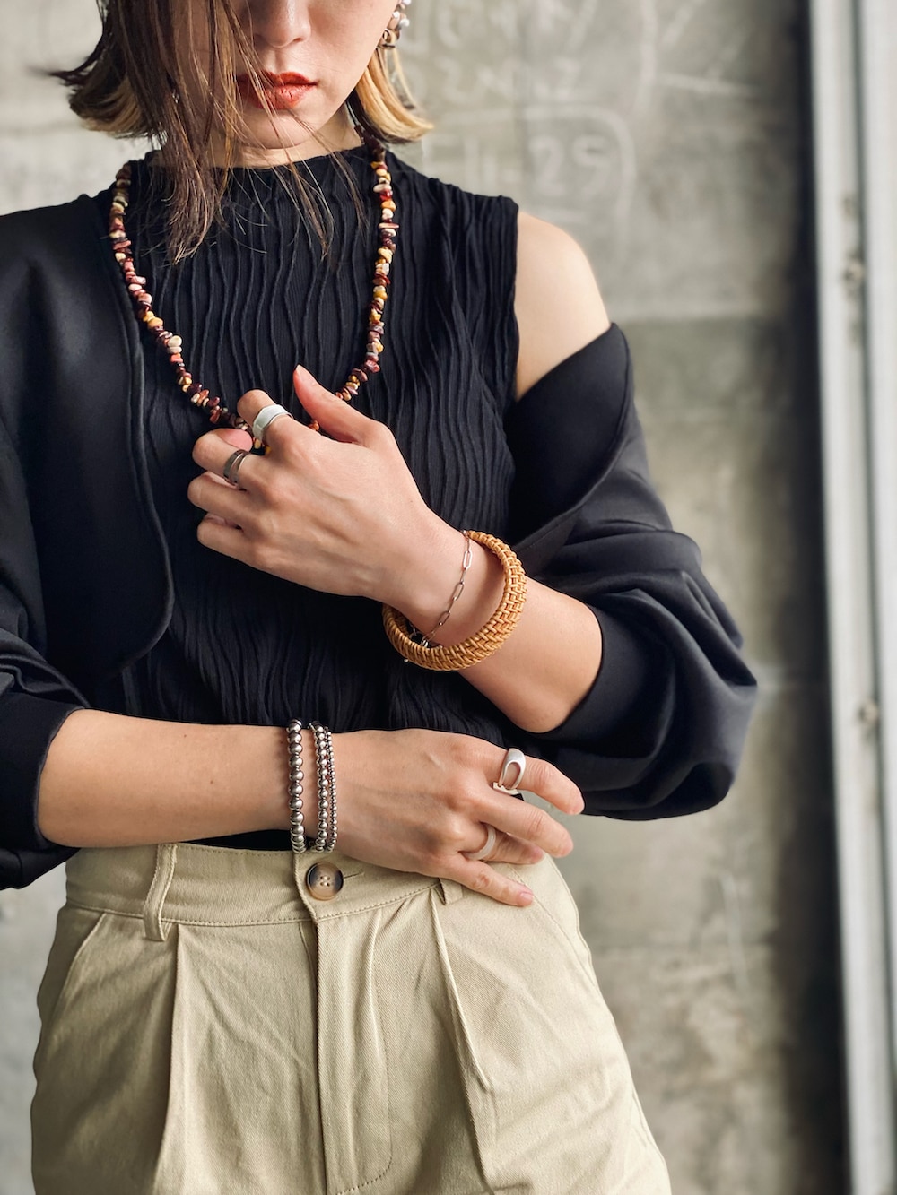 ブラック系のカーディガン/ボレロ、ベージュ系のチノパンツ、ブラウン系のサンダルを着用したレディースの春コーディネートの5枚目の写真