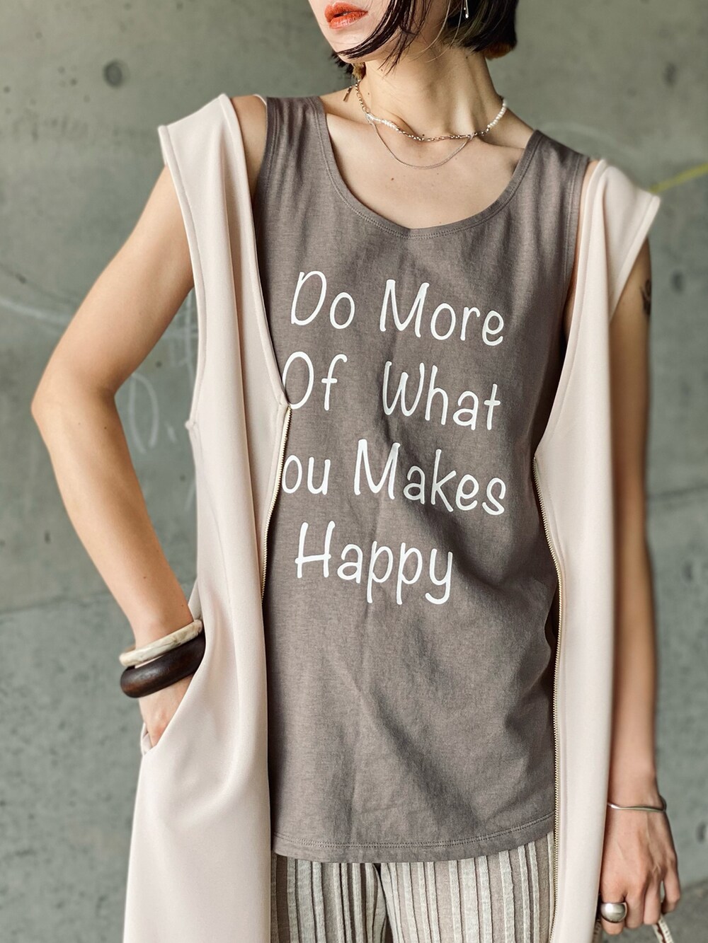 ホワイト系のタンクトップ、ホワイト系のワンピース、ブラウン系のショルダーバッグを着用したレディースの夏コーディネートの2枚目の写真