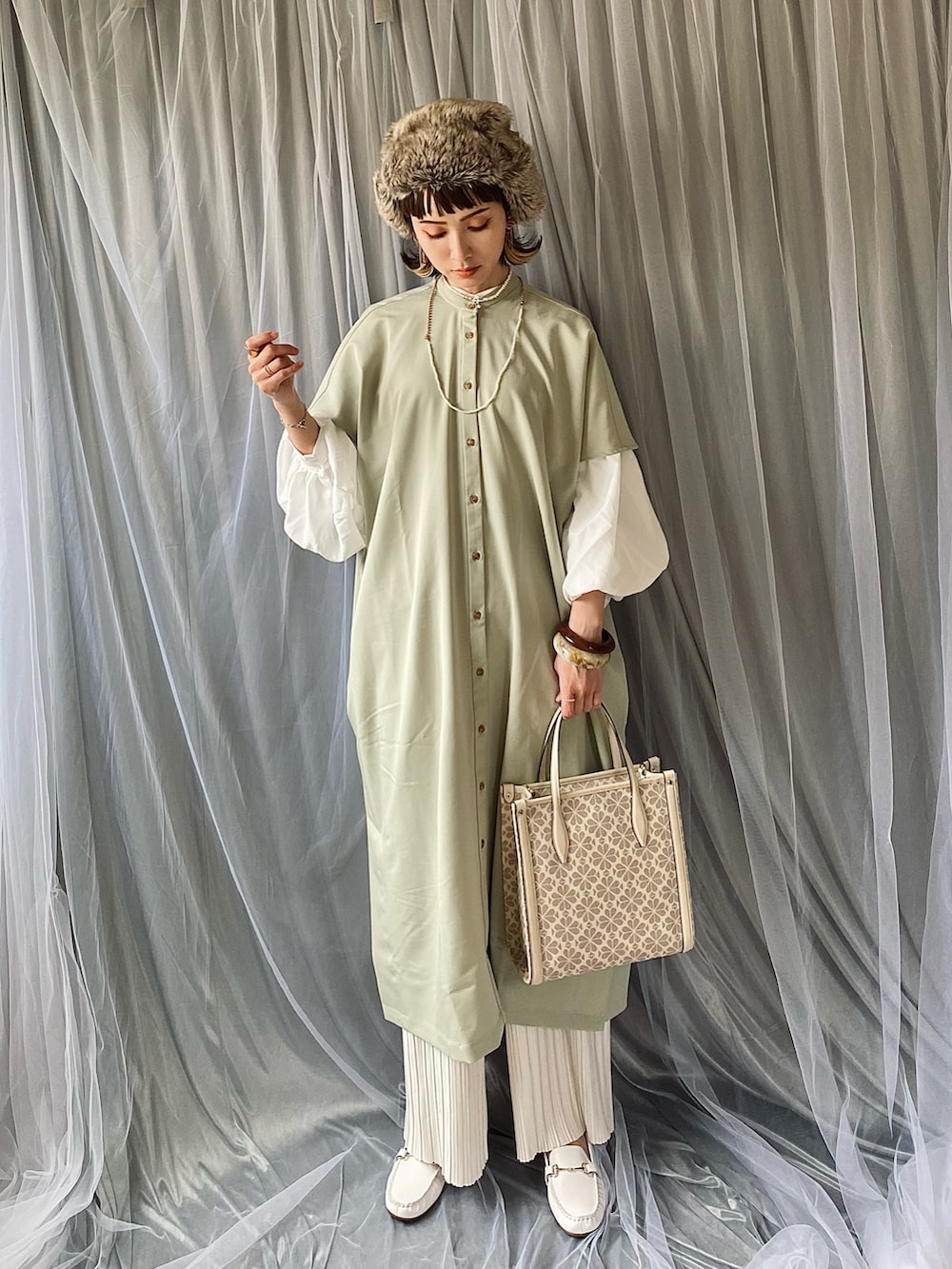 グリーン系のワンピース、ホワイト系のシャツ/ブラウス、その他のハンドバッグを着用したレディースの春コーディネートの2枚目の写真