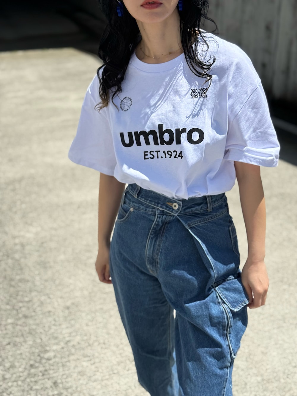 ホワイト系のTシャツ/カットソー、グレー系のショルダーバッグ、ブラック系のキャップを着用したレディースの春コーディネートの2枚目の写真