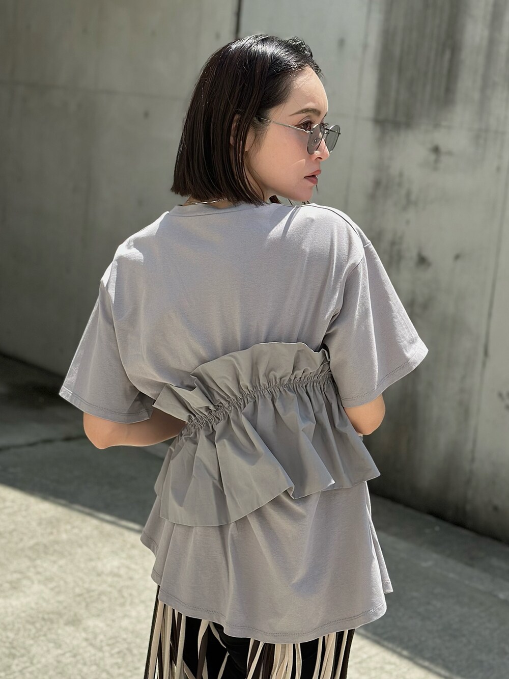 グレー系のTシャツ/カットソーを着用したレディースの春コーディネートの3枚目の写真