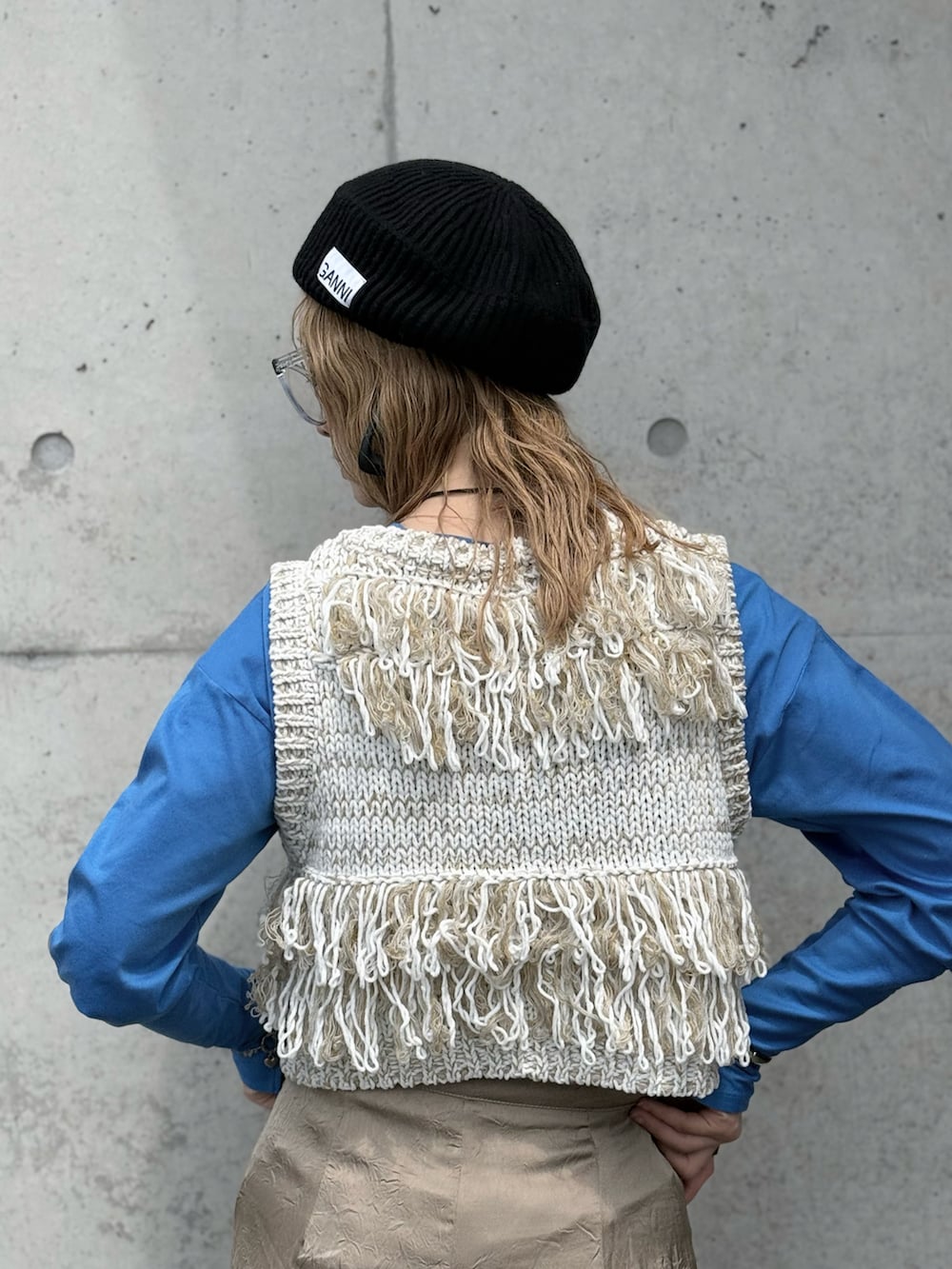 ブラック系のハンドバッグ、ブルー系のTシャツ/カットソー、ホワイト系のベストを着用したレディースの春コーディネートの3枚目の写真