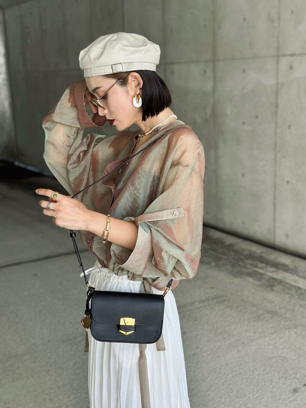 ベージュ系のシャツ/ブラウス、ブラック系のメッセンジャーバッグ、ホワイト系のサンダルを着用したレディースの秋コーディネートの4枚目の写真