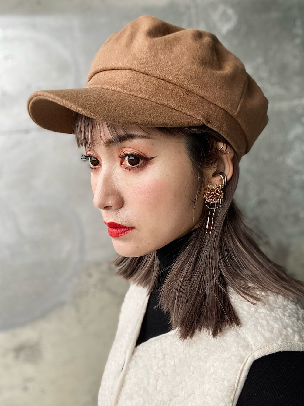 ブラウン系のスカート、ブラック系のTシャツ/カットソー、ブラウン系のブーツを着用したレディースの春コーディネートの4枚目の写真