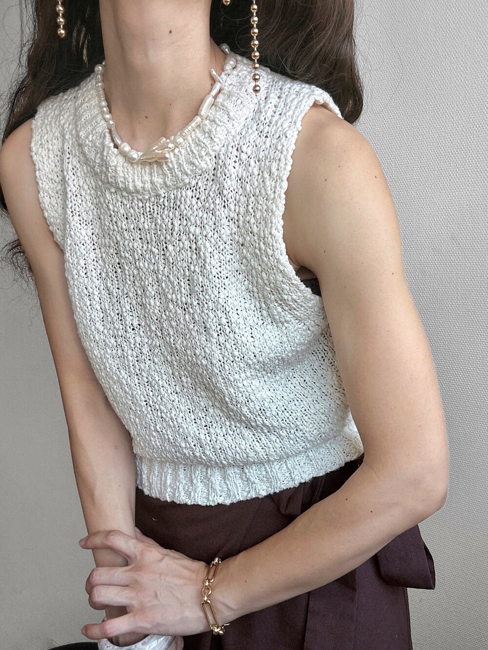 ホワイト系のベスト、ブラウン系のその他パンツ、ブラウン系のショルダーバッグを着用したレディースの夏コーディネートの4枚目の写真