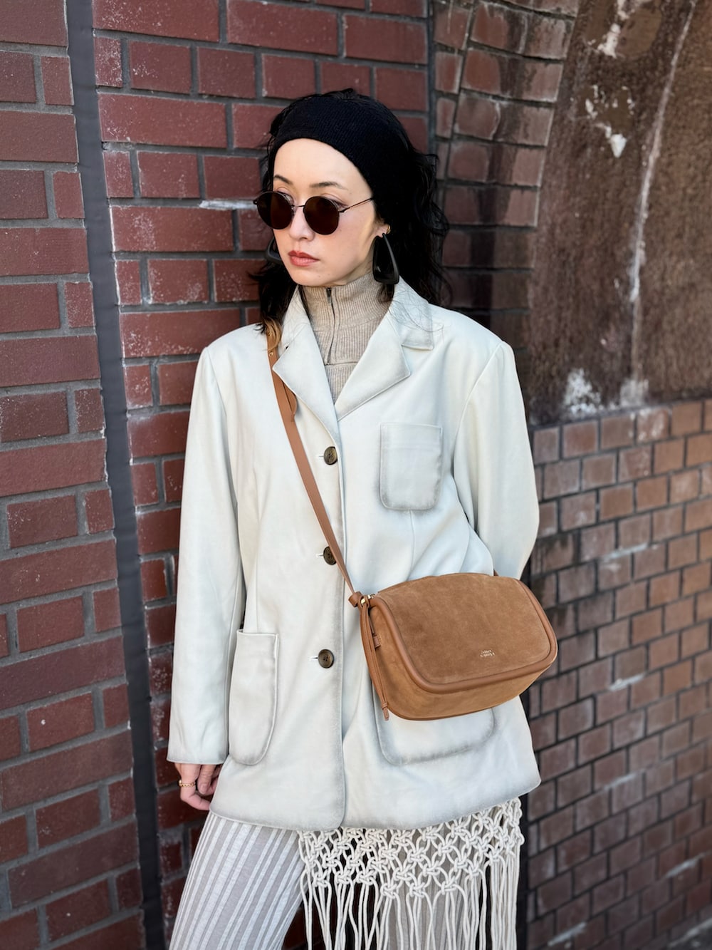 ブラック系のブーツ、グレー系のテーラードジャケット、ブラウン系のショルダーバッグを着用したレディースの冬コーディネートの2枚目の写真