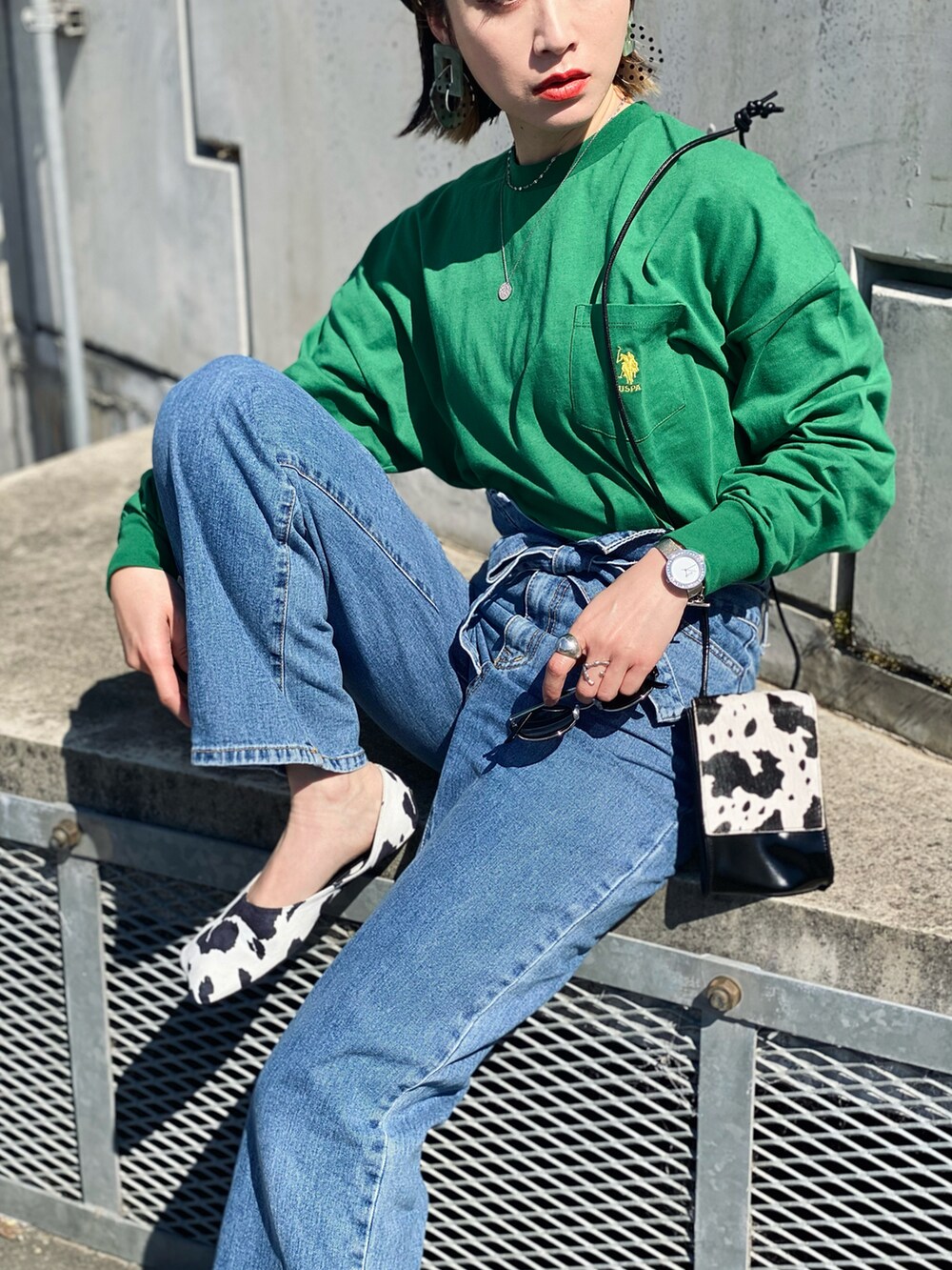 グリーン系のTシャツ/カットソー、その他のパンプス、ブルー系のデニムパンツを着用したレディースの春コーディネートの2枚目の写真